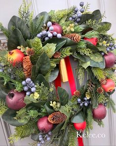 a christmas wreath with pine cones, berries and evergreens on the front door handle