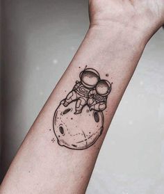 an astronaut tattoo on the wrist