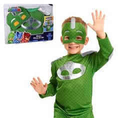 a young boy wearing a green costume and holding his hands up in the air with one hand