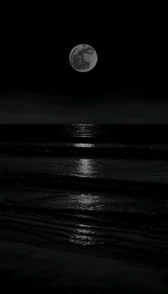 the full moon shines brightly over the ocean at night with black and white colors