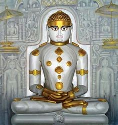 a white and gold statue sitting in front of a wall