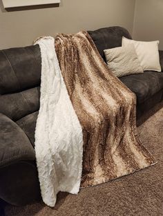 a brown and white blanket sitting on top of a couch