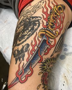 a person with a tattoo on their arm holding a knife and some other things in the background