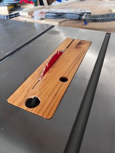 a piece of wood that is laying on top of a metal surface with a knife sticking out of it