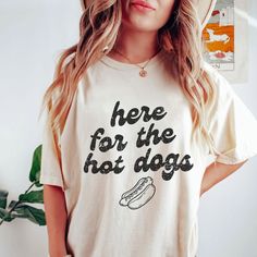 Here For The Hot Dogs Shirt, Hot Dog T-Shirt, Tailgate Shirt, Baseball T-Shirt, Gift for Hot Dog Lovers, Summertime Hot Dog Shirt This classic unisex jersey short sleeve tee fits like a well-loved favorite. Soft cotton and quality print make users fall in love with it over and over again. These t-shirts have-ribbed knit collars to bolster shaping. The shoulders have taping for better fit over time. Dual side seams hold the garment's shape for longer.  .: 100% Airlume combed and ringspun cotton (fiber content may vary for different colors) .: Light fabric (4.2 oz/yd² (142 g/m .: Retail fit .: Tear away label .: Runs true to size, size UP 1-3 sizes for an oversized look *Unfortunately, we do not accept exchanges, cancellations, or returns since each product is made to order. If you notice an Hot Dog Shirt, Cotton Short Sleeve T-shirt With Dog Print, Funny Dog Print Crew Neck T-shirt, Dog Print Crew Neck Graphic Tee, Summer Dog Print Relaxed Fit T-shirt, Summer Relaxed Fit T-shirt With Dog Print, Relaxed Fit Short Sleeve Tops With Dog Print, Cotton Crew Neck Top With Dog Print, Summer Dog Print Graphic Tee