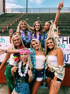 a group of women standing next to each other in front of a bleachers