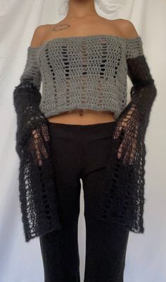 a woman wearing black pants and a cropped top with crochet on it