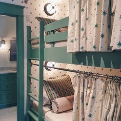 a bunk bed in a room with green walls and curtains on the wall, next to a window