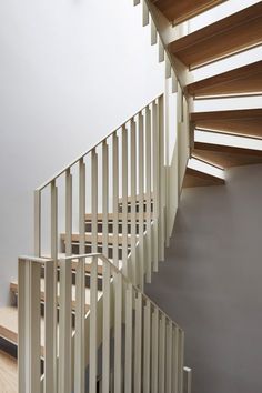 a white staircase with wooden handrails in a house