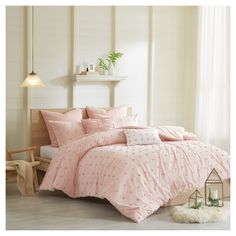 a bed with pink comforters and pillows in a room