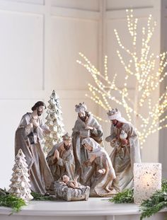 a group of figurines sitting on top of a table next to a christmas tree