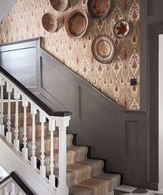 there are baskets on the wall next to the stair railing and carpeted flooring