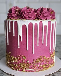 a pink and gold decorated cake sitting on top of a table