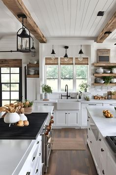 a kitchen with white cabinets and black counter tops, wooden shelves above the stovetop