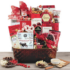 the holiday gourmet gift basket is filled with treats and snacks, along with crackers