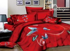 a bed with red sheets and butterflies on it