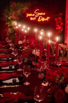 a long table is set with candles and red napkins