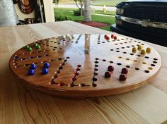 a board game sitting on top of a wooden table next to a black car in the background