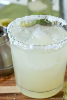 a margarita sitting on top of a wooden cutting board