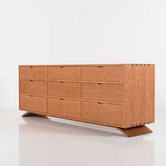 a wooden dresser sitting on top of a white floor