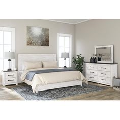 a white bed sitting in a bedroom on top of a wooden floor