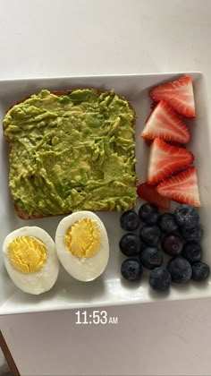 an egg, strawberries, and toast with avocado in it on a white plate