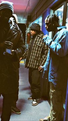 three men standing next to each other on a subway