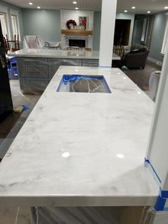 a kitchen counter is being installed in the middle of a room with chairs and couches