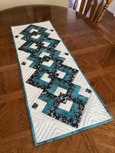 a quilted table runner sitting on top of a wooden floor next to a stair case