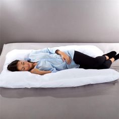 a woman laying on top of a white pillow