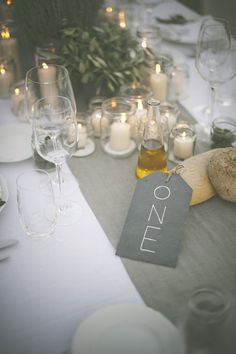 an image of a table setting with candles and place cards on it for guests to sign