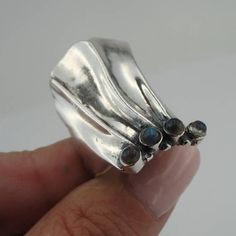 Stunning NEW handcrafted 925 sterling silver ring.The band is made of polished curved 925 sterling silver with four round Labradorite stones 3mm each.Must see!!!Size: 9 Dimensions: Front width: 40mm / 1.574 in., Back width: 5mm / 0.196 in. Stamped 925. This beauty will be sent to you in a gift package. (All stains, if are any, are due to camera). * THIS PHOTO DOES NOT DO JUSTICE TO THIS UNIQUE RING !Please feel free to contact us at any matter. Sterling Silver Opal Ring, Purple Stone Rings, Long Ring, Silver Opal Ring, Blue Stone Ring, Labradorite Jewelry, Gift Package, Handcrafted Rings, Labradorite Ring