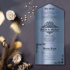 the wedding card is next to some white flowers and gold confetti scattered around it