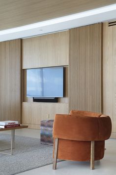 a living room with a couch, chair and flat screen tv mounted on the wall