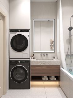 a washer and dryer in a bathroom next to a tub with a mirror