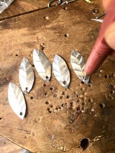 a person is working with metal parts on a piece of wood and some screws