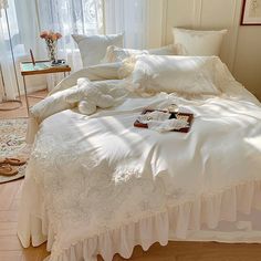 a bed with white sheets and pillows in a room