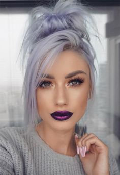 a woman with grey hair and purple lipstick