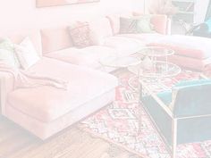 a living room filled with lots of furniture and rugs on top of a hard wood floor