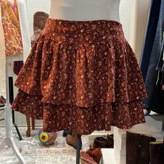 This Adorable Skirt Features Two Layers Of Tiered, Corduroy Floral, And Elastic Smocking In The Back For A Great Flexible Fit Brown Tiered Skirt Bottoms For Fall, Brown Tiered Skirt For Fall, Floral Print Skirted Bottoms For Fall, Non-stretch Cotton Skirt For Fall, Floral Print Tiered Skirt For Fall, Tiered Floral Print Skirt For Fall, Fall Floral Print Tiered Skirt, Cotton Mini Skirt For Fall, Fall Cotton Mini Skirt