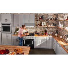 a woman standing in a kitchen preparing food on top of a stove next to an oven