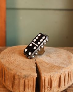 a black and white polka dot ring sitting on top of a piece of wood