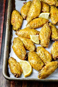 chicken wings with lemon slices on a baking sheet