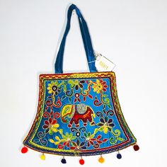 This Is A Lovely, Bright Embroidered Shoulder/Handbag From India. It Is Very Colorful With A Base Of Blue And Needle Work Of Green, Red Purple, Yellow, Magenta, Orange And Silver Threading Holding And Connecting The Flowers And Swirls Together And Surrounding A Lucky Elephant. There Are Also Tiny Mirrors To Reflect The Light. The Back Is Solid Blue Silk (No Embellishment). The Inside Has One Small Zippered Pocket In A Large Compartment And Is Fully Lined In A Matching Light Cotton. The Bag Zips Tiny Mirrors, Embroidery Shoulder, Orange And Silver, Frye Bags, Indian Blue, Lucky Elephant, Tan Bag, Tapestry Bag, Printed Purse