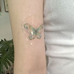 a woman's arm with a butterfly tattoo on the left side of her arm