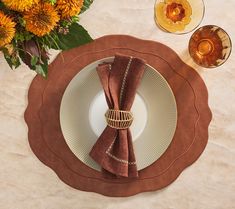 a place setting with napkins and flowers on the table