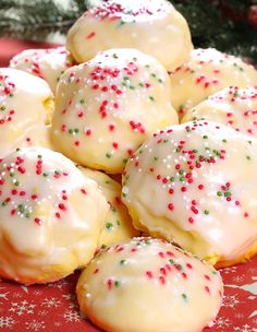 christmas cookies with white frosting and sprinkles are on a red plate