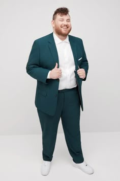 a man in a green suit and white shirt is standing with his hands on his hips