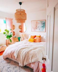 a bedroom with a bed, rugs and pictures on the wall above it is decorated in pastel colors