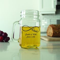 a glass jar filled with liquid sitting on top of a counter next to some grapes